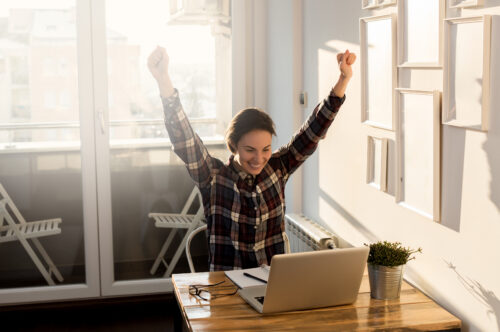 person happy in front of computer celebrating