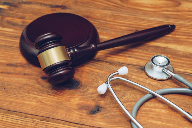 Stethoscope with judge gavel. Concept of healthcare and medicine, malpractice, legal system.