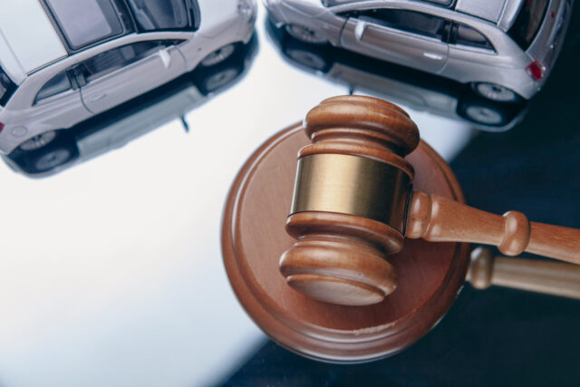 Model of car and gavel. Accident lawsuit or insurance, court case.