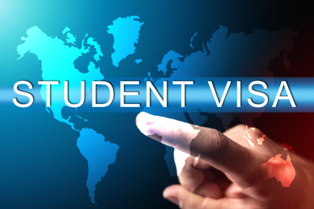 Obtaining a student visa. Human hand next to a virtual screen. Concept - services for obtaining a student visa. Admission to study at a foreign university. Student visa logo on world map background