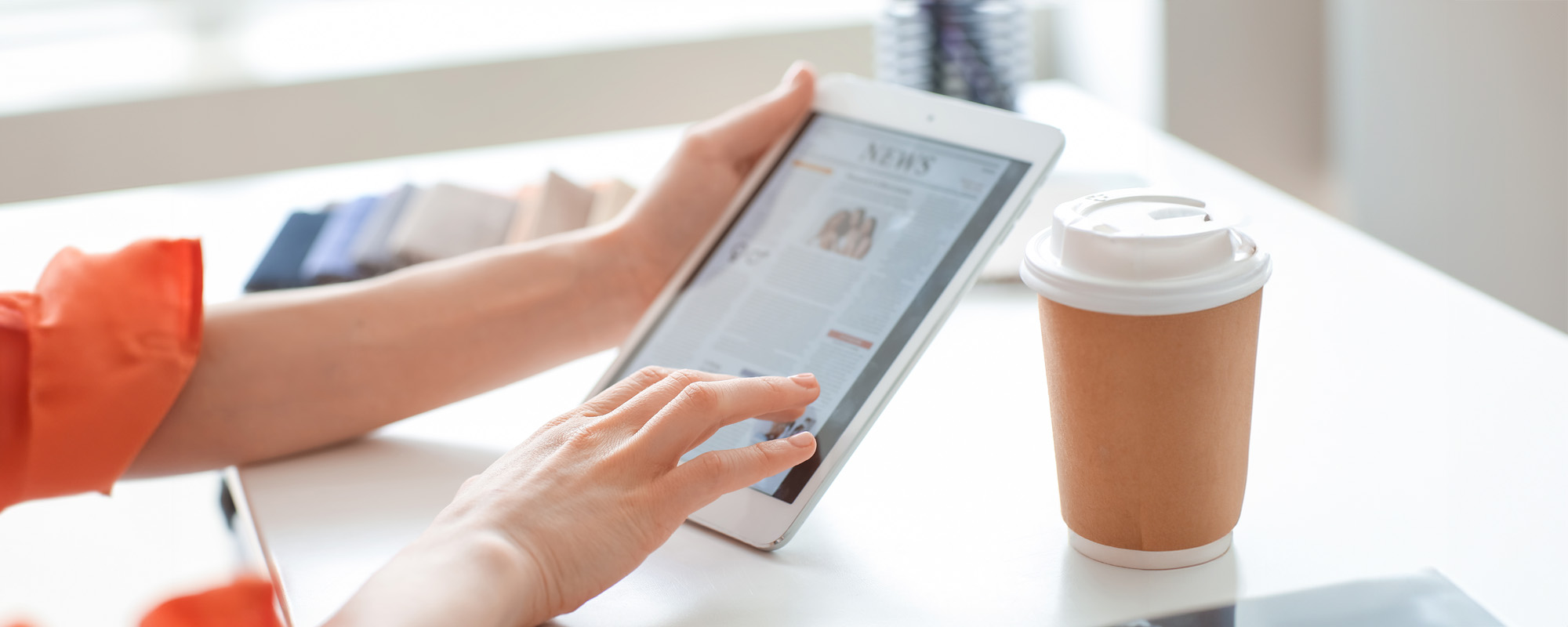 Young woman reading news on tablet computer screen at home