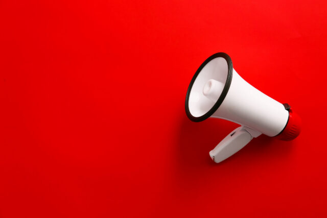Modern megaphone on color background